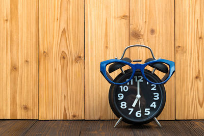 Close-up of clock on table against wall