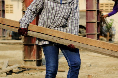 Low section of man standing on wood