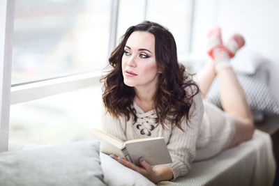 Portrait of woman relaxing on sofa at home