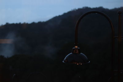 Close-up of illuminated lighting equipment hanging at night