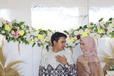 Young woman standing by flowering plants