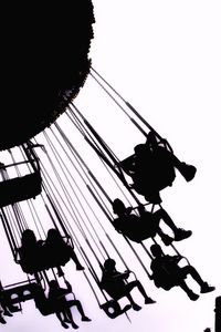 Low angle view of silhouette men against sky