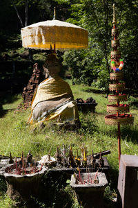 Statue by temple against trees