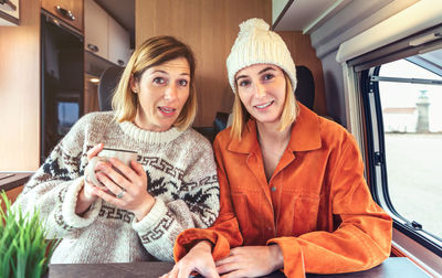 Women talking looking at camera on videoconference from their campervan