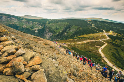 Group of people on mountain against sky