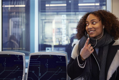 Young woman listening music in train