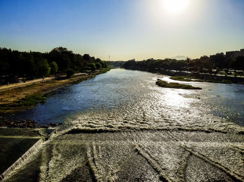 Scenic view of river against sky at sunset