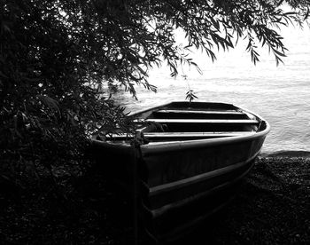 Boat moored on tree against sky