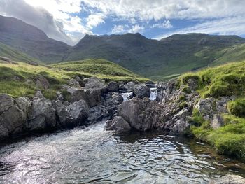 Scenic view of river amidst mountains against sky