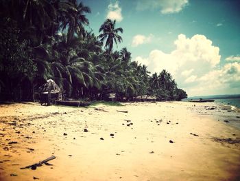 Scenic view of beach against cloudy sky