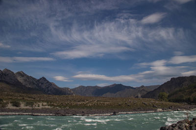 Scenic view of lake by mountains against sky