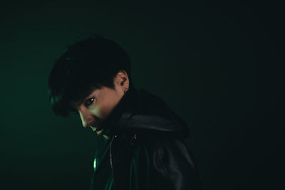 Portrait of young man against black background