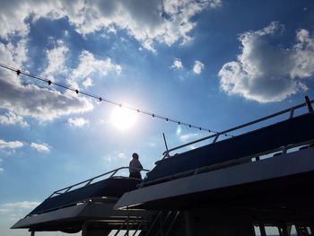 Low angle view of men working against sky