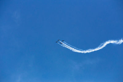 Low angle view of airplane flying in sky airshow