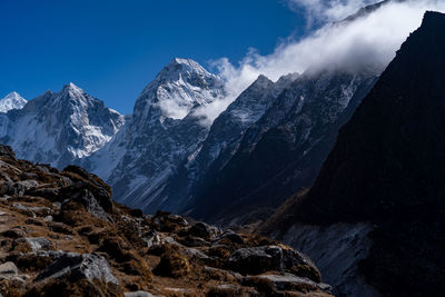 Scenic view of snowcapped mountains against blue sky