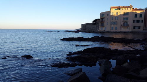 Scenic view of sea against clear sky at sunset