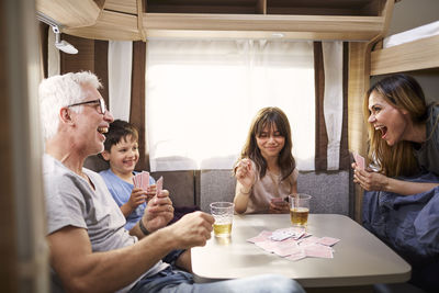 Family playing cards in camper van