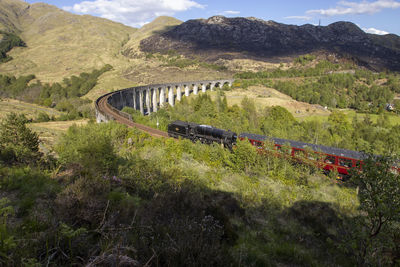 The jacobite steam train crossing the glenfinnan viaduct near fort william, uk