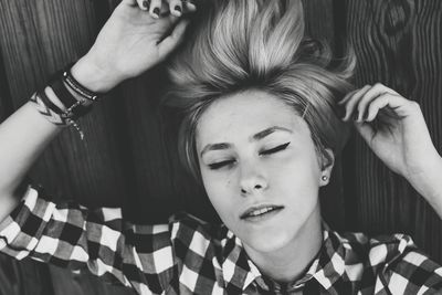 High angle view of young woman lying down on wood