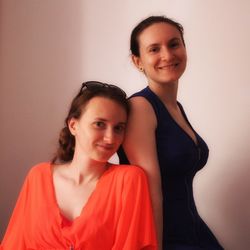 Portrait of smiling young woman against gray background