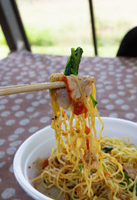Close-up of noodles in bowl on tablecloth