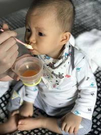 High angle view of cute boy drinking orange