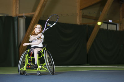 Girl in wheelchair playing tennis