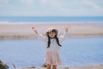 Full length of girl standing by sea against sky