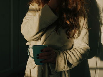 Midsection of woman holding coffee cup