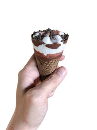 Close-up of hand holding ice cream against white background
