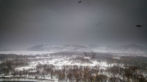 Scenic view of snow covered land against sky