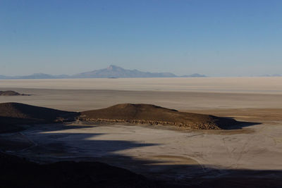 Scenic view of desert against clear blue sky