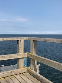 Pier over sea against blue sky