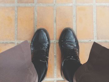 Low section of man standing on tiled floor