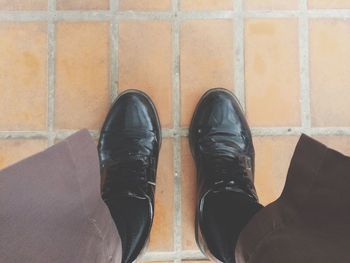 Low section of man standing on tiled floor