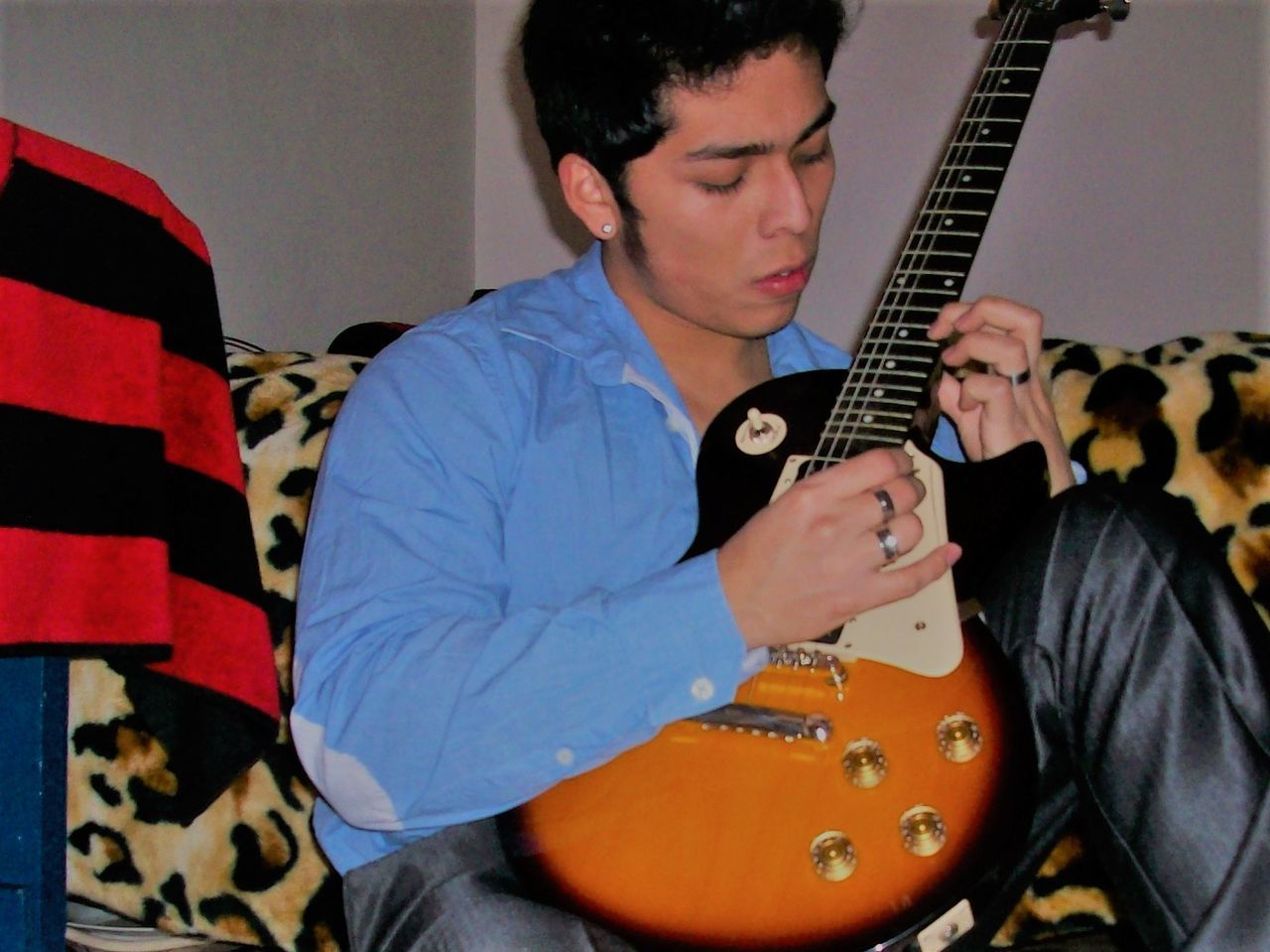 MAN PLAYING GUITAR AT HOME