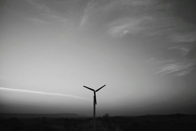 Silhouette of wind turbines against sky