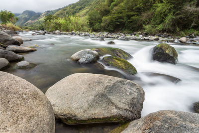 River flowing amidst rocks against sky