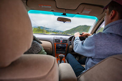 Close-up of a young couple of lovers riding a car on a trip to the mountains.