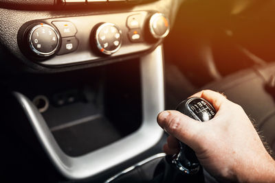 Close-up of hand holding camera in car