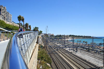 Panoramic view of railroad tracks against clear blue sky