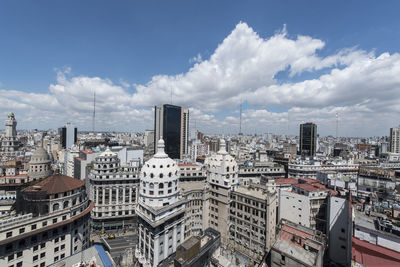 High angle view of city buildings against cloudy sky