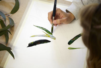 Midsection of woman painting on table