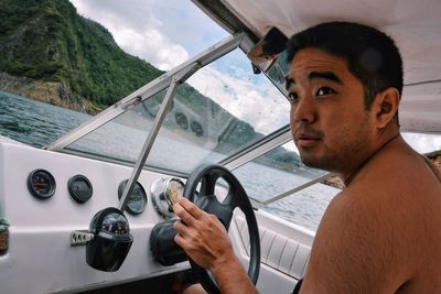 Young man driving boat