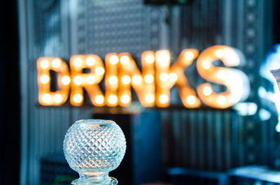 Crystal container against illuminated text at bar