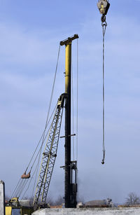 Low angle view of cranes against blue sky