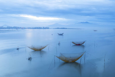 Boats moored in sea against sky