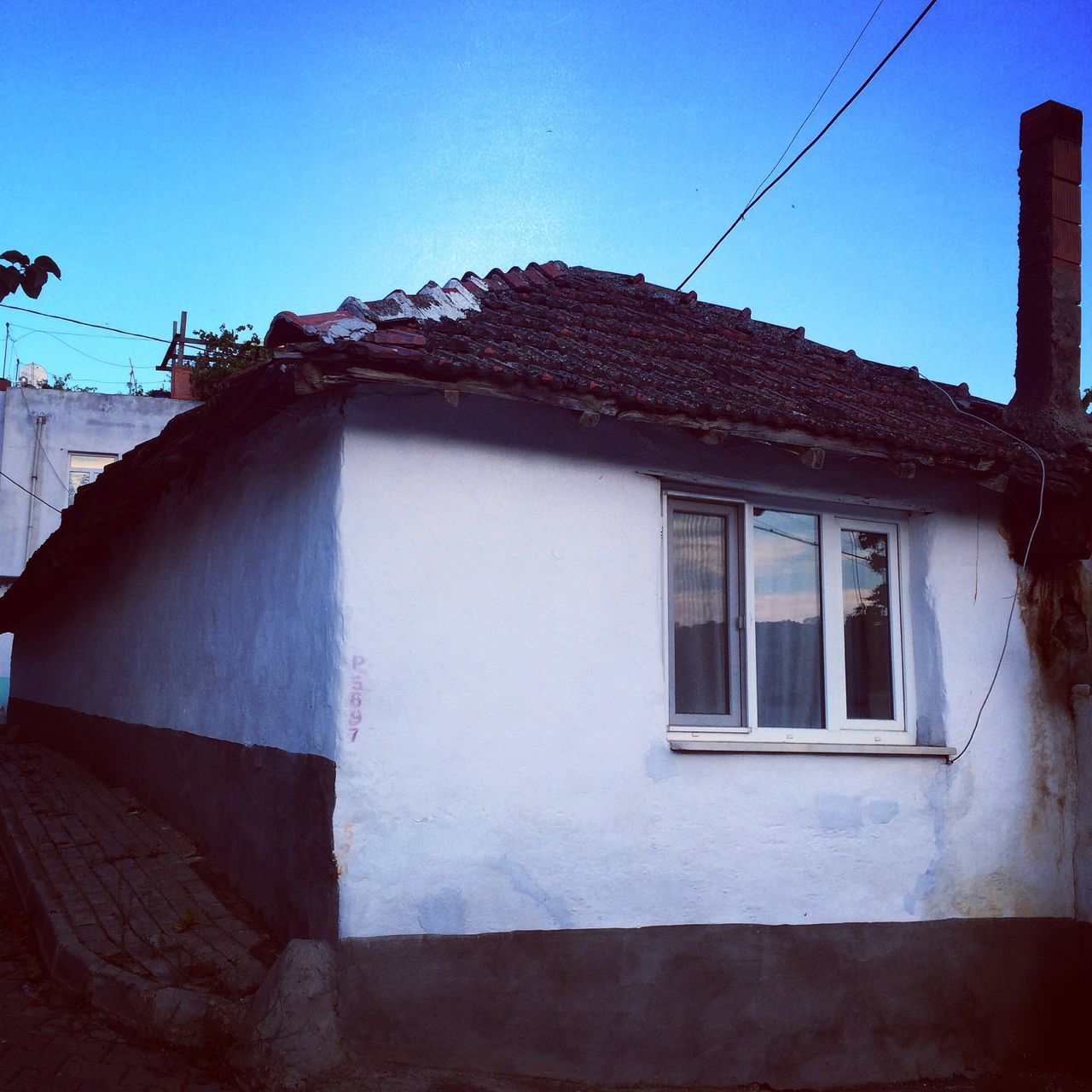 architecture, building exterior, built structure, window, clear sky, blue, house, low angle view, residential structure, residential building, building, day, sky, outdoors, power line, sunlight, no people, old, exterior, door