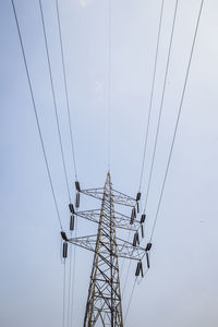 Perspective of power cable and high voltage tower in cloudy sky