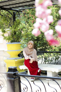 Portrait of a smiling young woman sitting outdoors